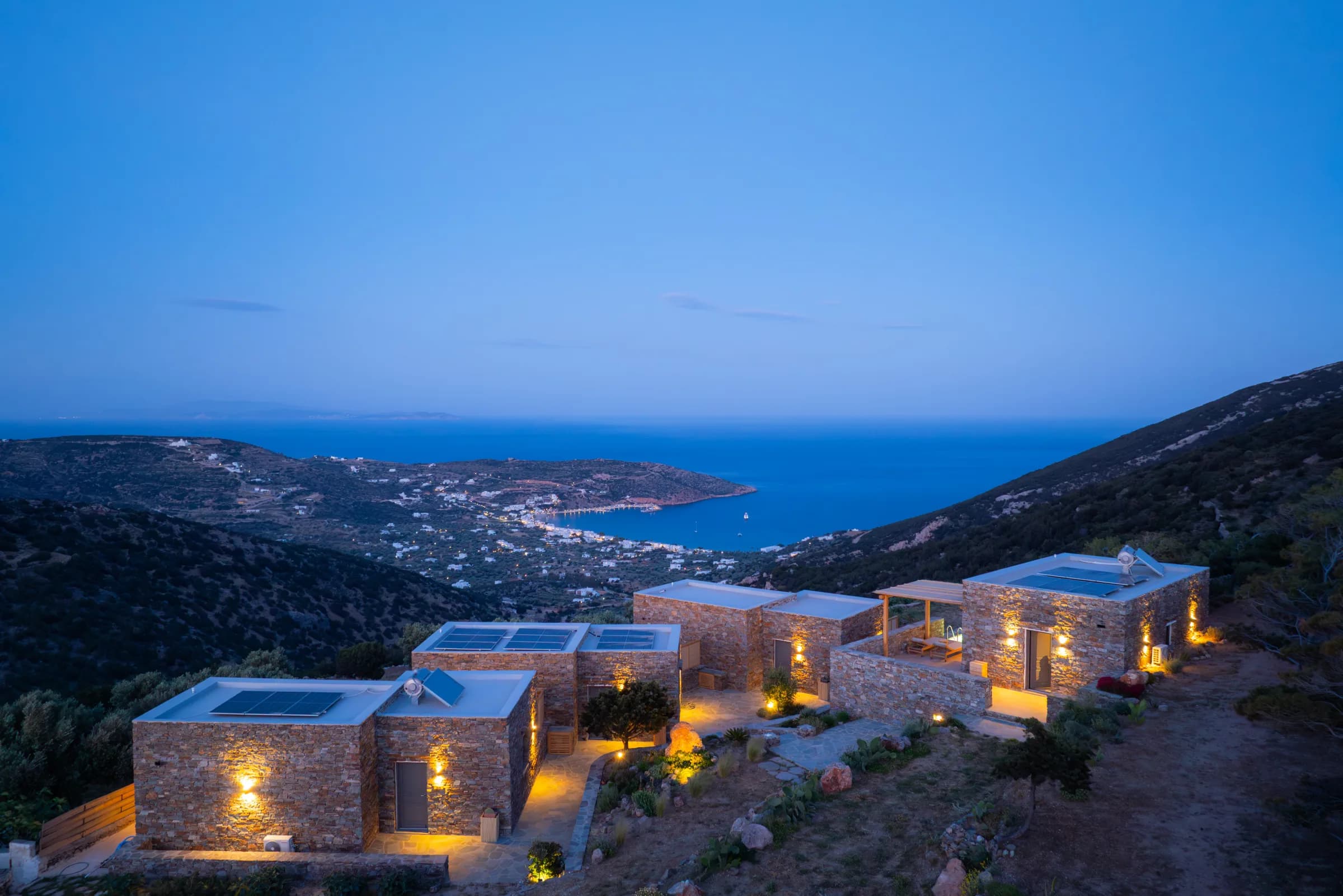 Refoulia Eco Suites — Suites with solar panels at dusk overlooking Sifnos bay